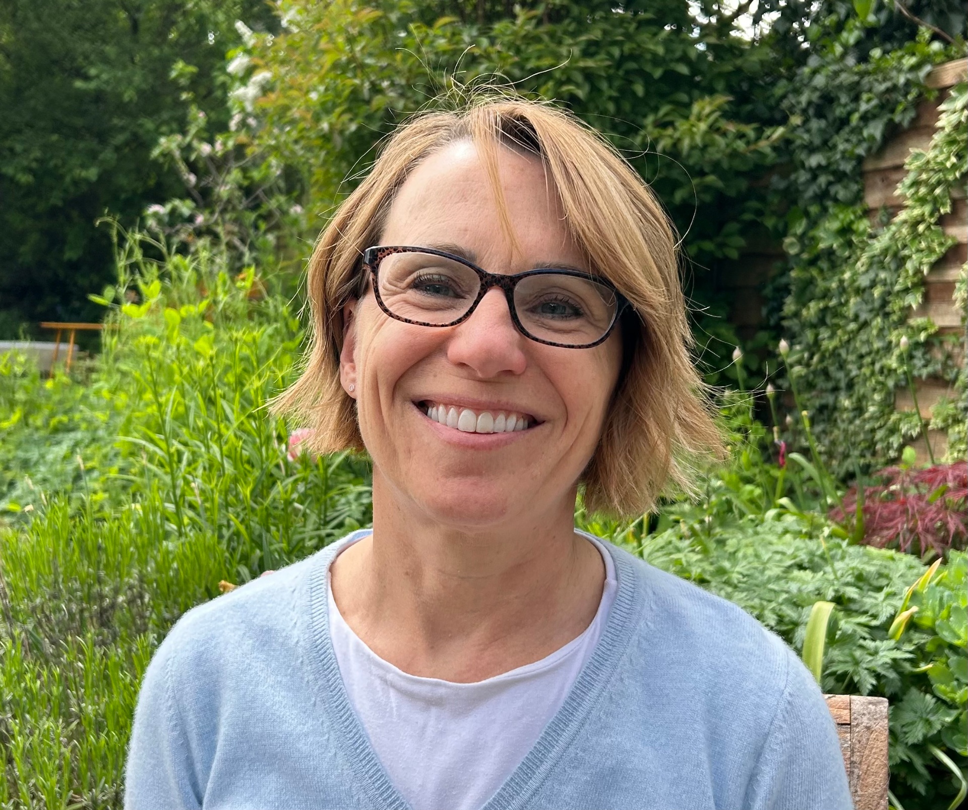 Sarah Pitkanen smiling in a green garden
